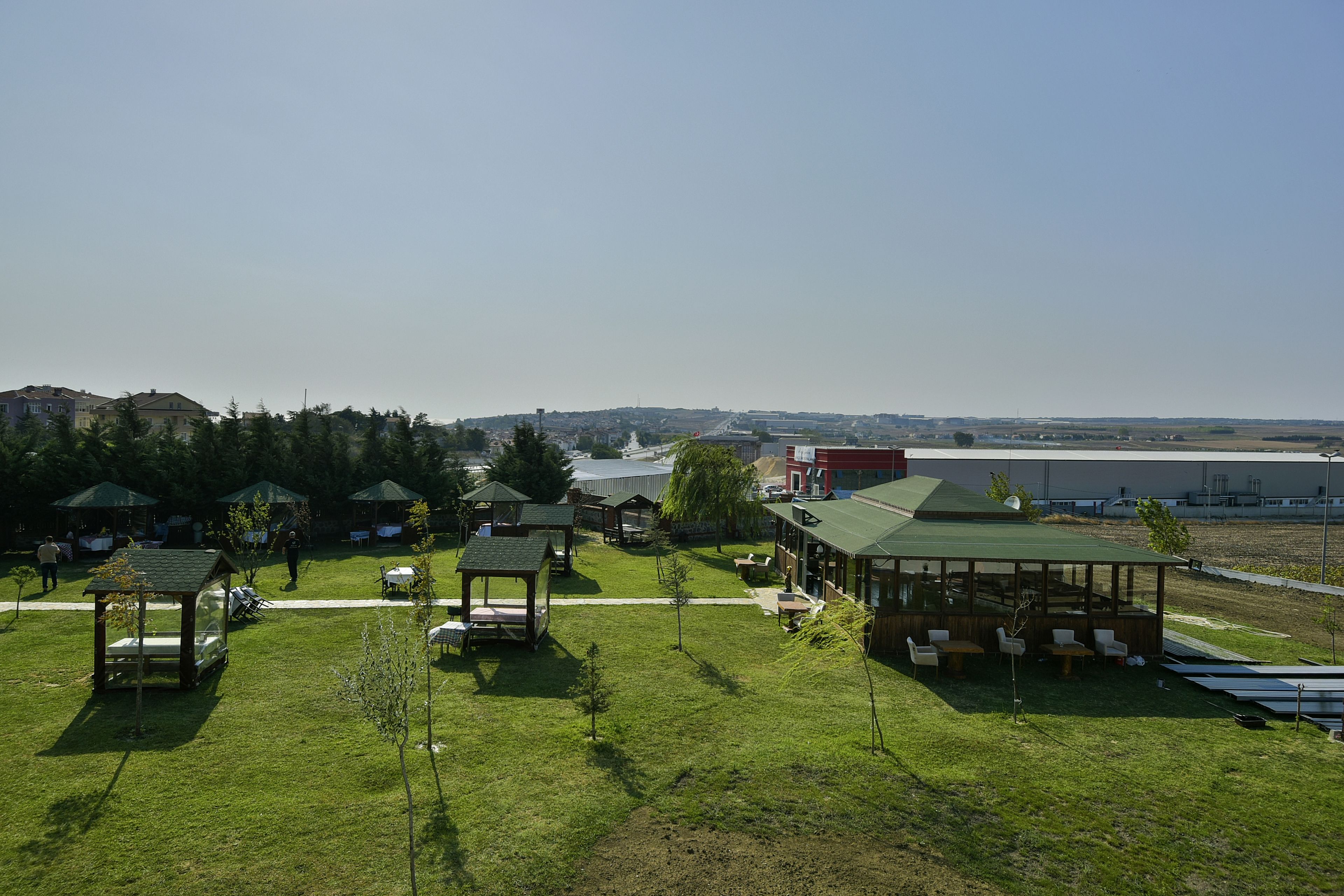 A grassy area with several wooden gazebos and a covered seating area.