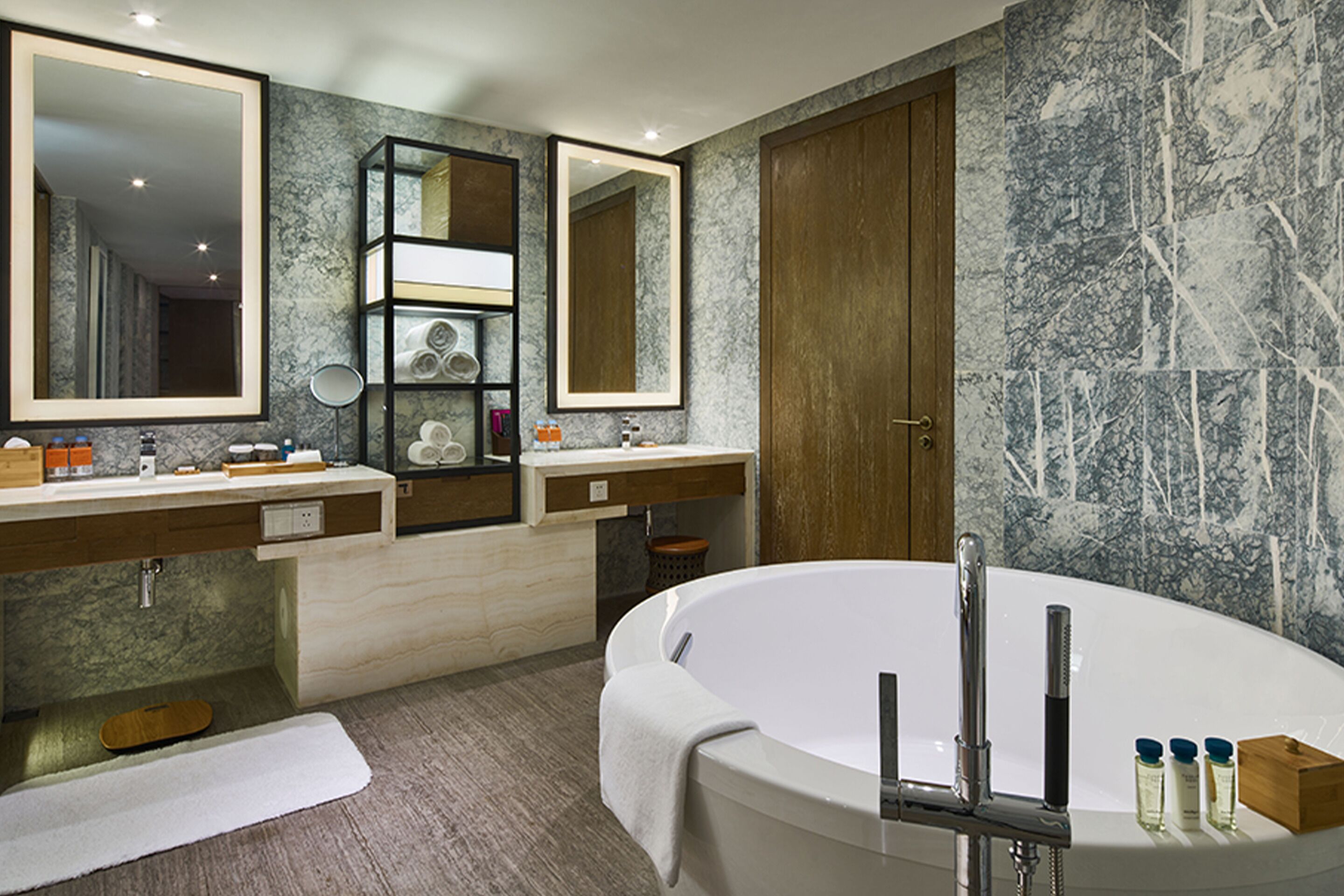 Ein modernes Badezimmer mit einer freistehenden Badewanne, zwei Waschbecken und einem großen Spiegel.