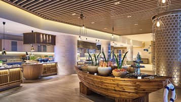 Una cocina moderna con armarios de madera, una isla central con encimera en forma de barco y una variedad de alimentos a la vista.