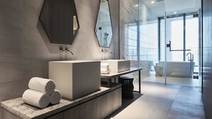 Une salle de bain moderne avec deux lavabos, un grand miroir et une baignoire.