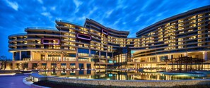 A multi-story hotel with a central courtyard and reflective pool.