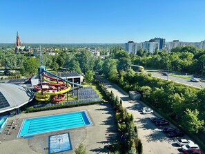 A swimming pool, water slides, and a parking area with cars. - Holiday Inn Dabrowa Gornicza by IHG (Dabrowa Gornicza)