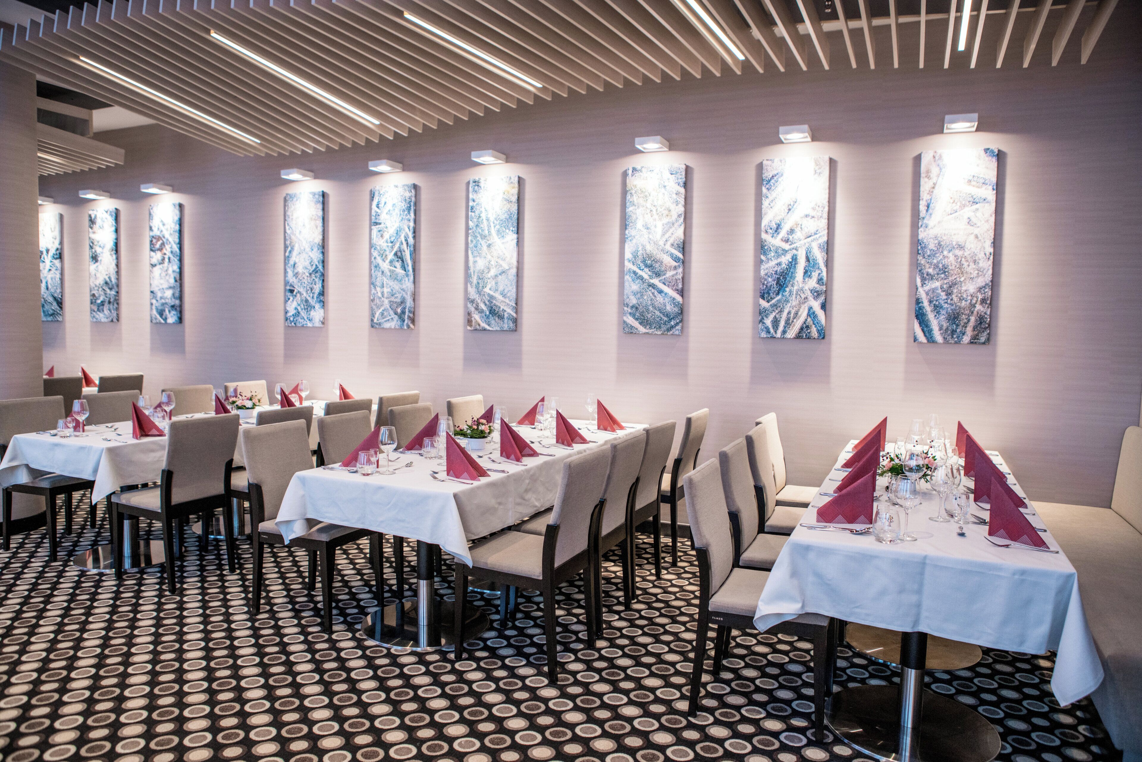 A dining area with tables set for service, chairs, and a patterned floor.