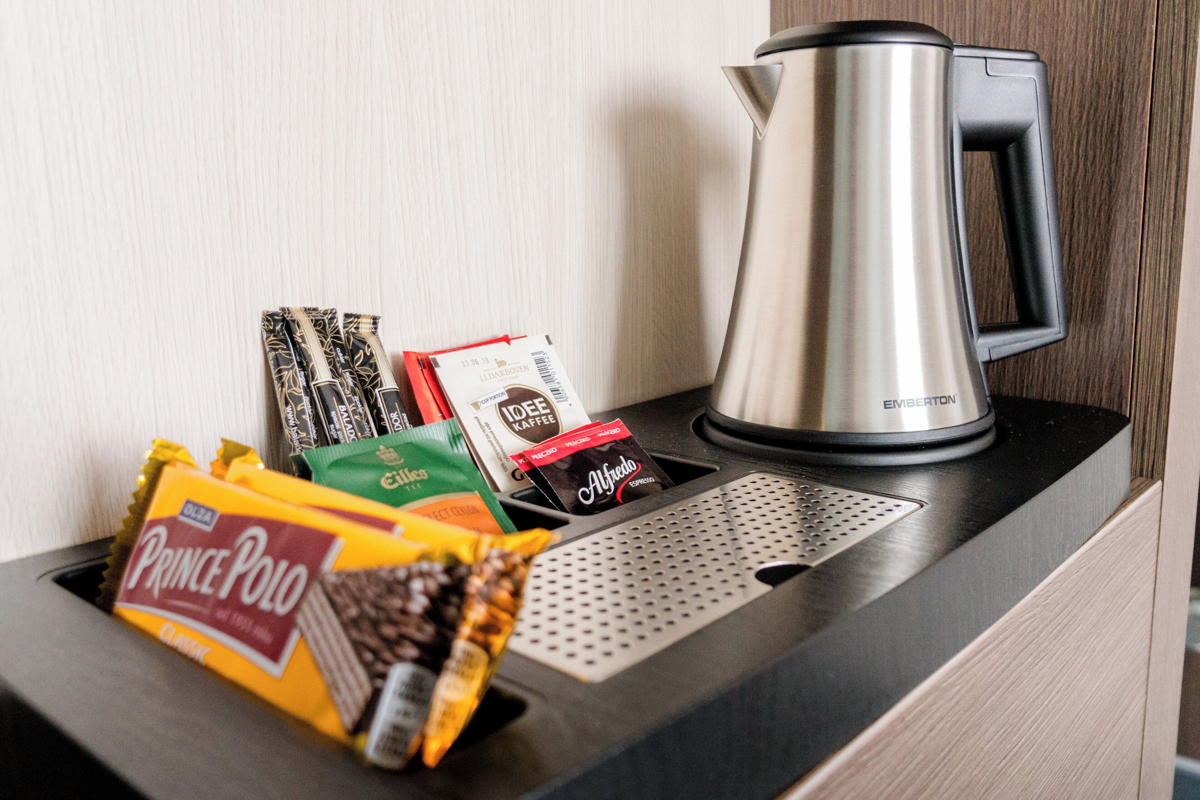 A coffee maker and a variety of coffee pods on a countertop.