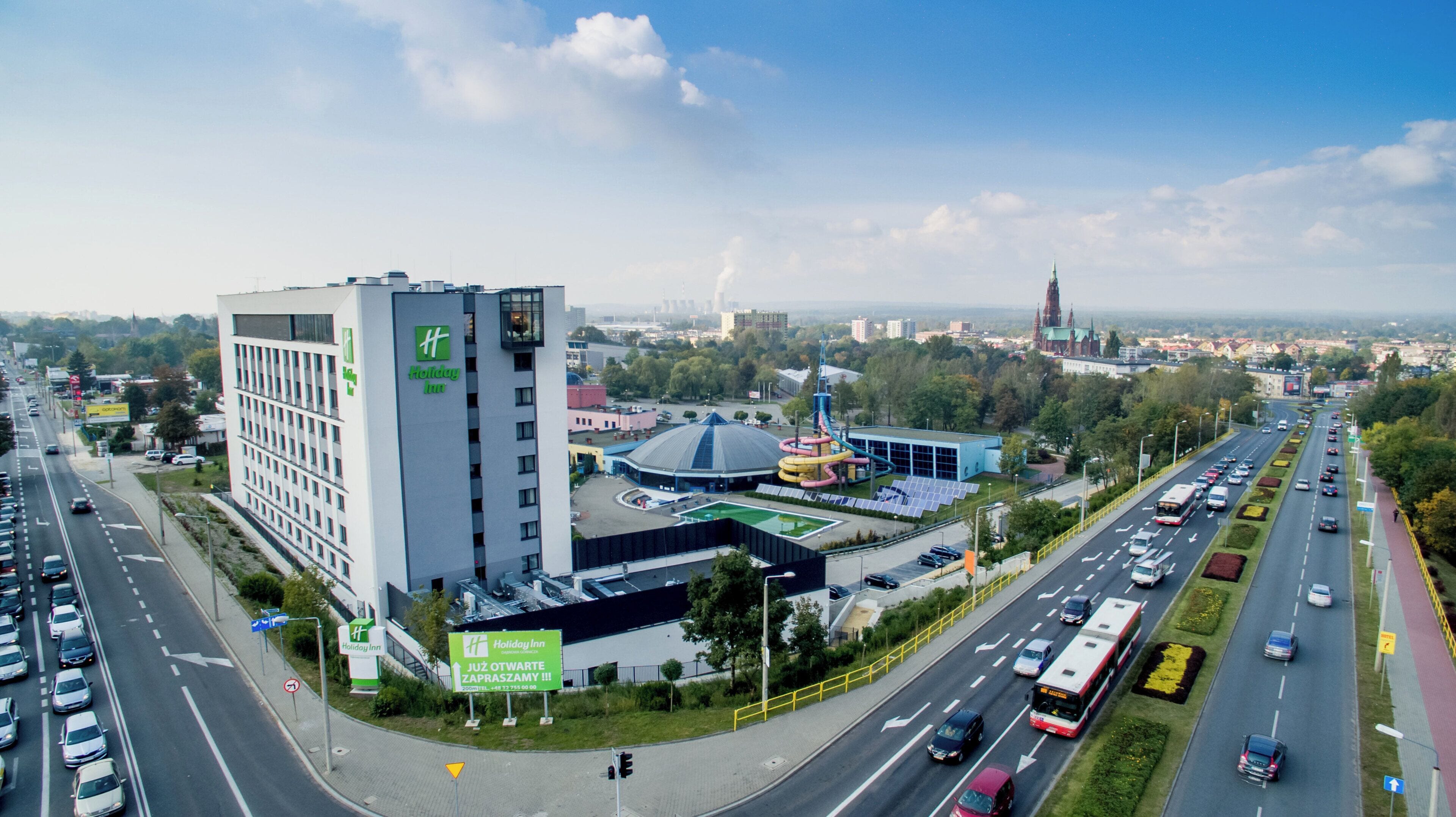 Un hôtel Holiday Inn au design moderne, situé près d’une route très fréquentée et d’un grand parc aquatique.