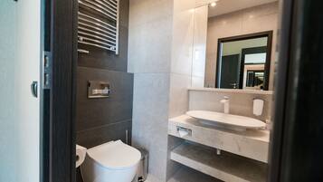 Un baño moderno con inodoro, bidé y lavamanos.