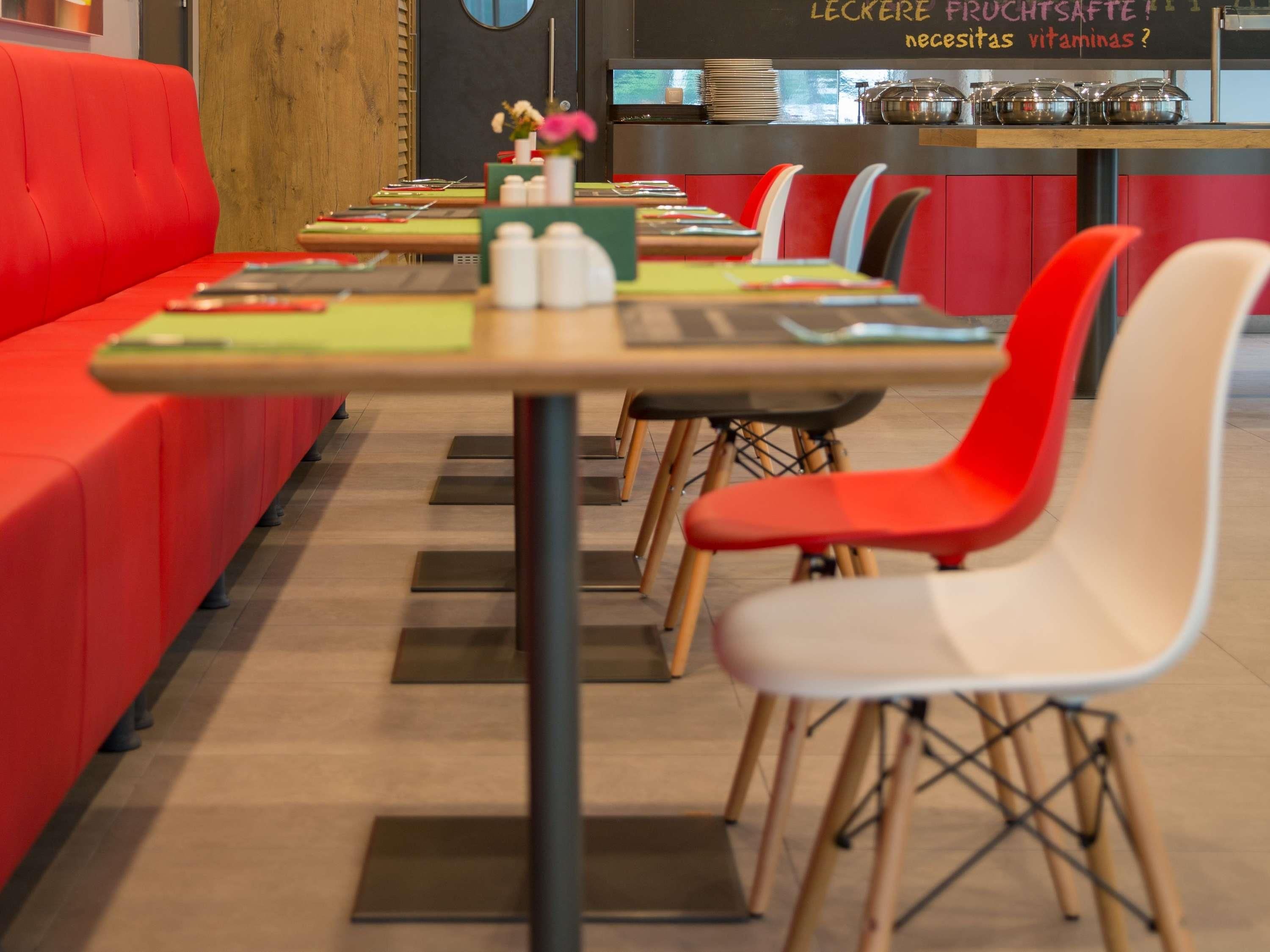 Un restaurante con asientos rojos y un mostrador que exhibe alimentos.