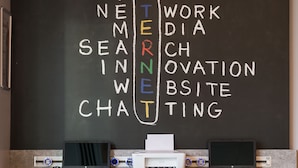 A workspace with a chalkboard displaying 'INTERNET' and other words, two chairs, and a desk with a laptop and printer. - ibis Istanbul West (Istanbul)