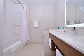 Une salle de bain moderne équipée d’une baignoire, d’une douche, d’un lavabo et d’un miroir.