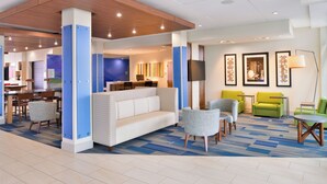 A hotel lobby with a reception desk, seating area, and artwork on the walls. - Holiday Inn Express & Suites Madison by IHG (Madison)