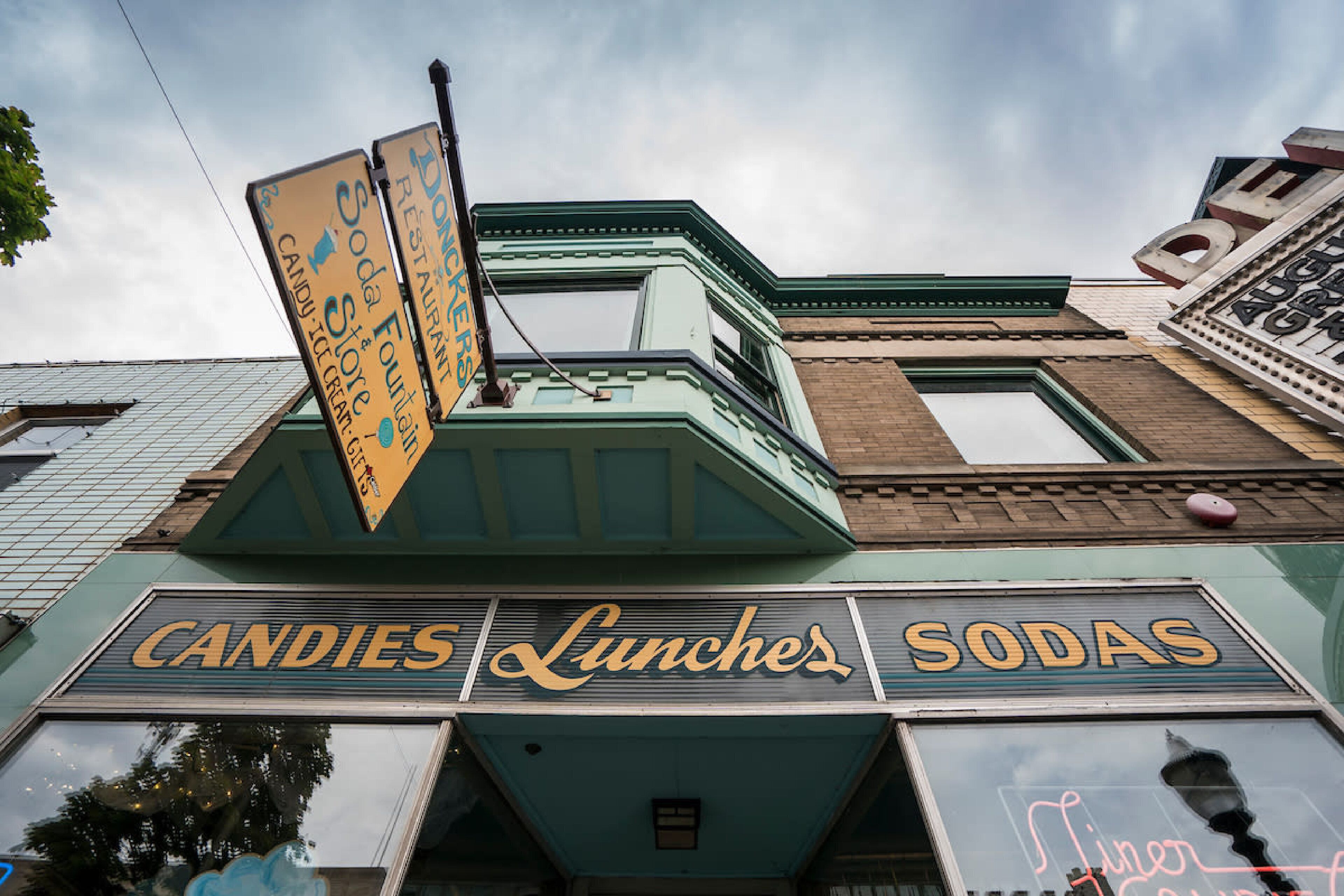 Un bâtiment sur lequel on peut lire l’inscription suivante : « Bonbons, plats préparés, boissons gazeuses ».