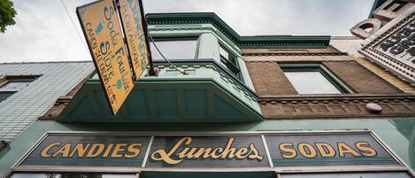 A building with a sign that reads "Candies, Lunches, Sodas."