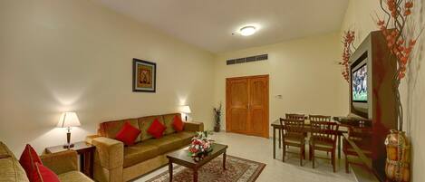 A living room with a sofa, coffee table, and dining area.