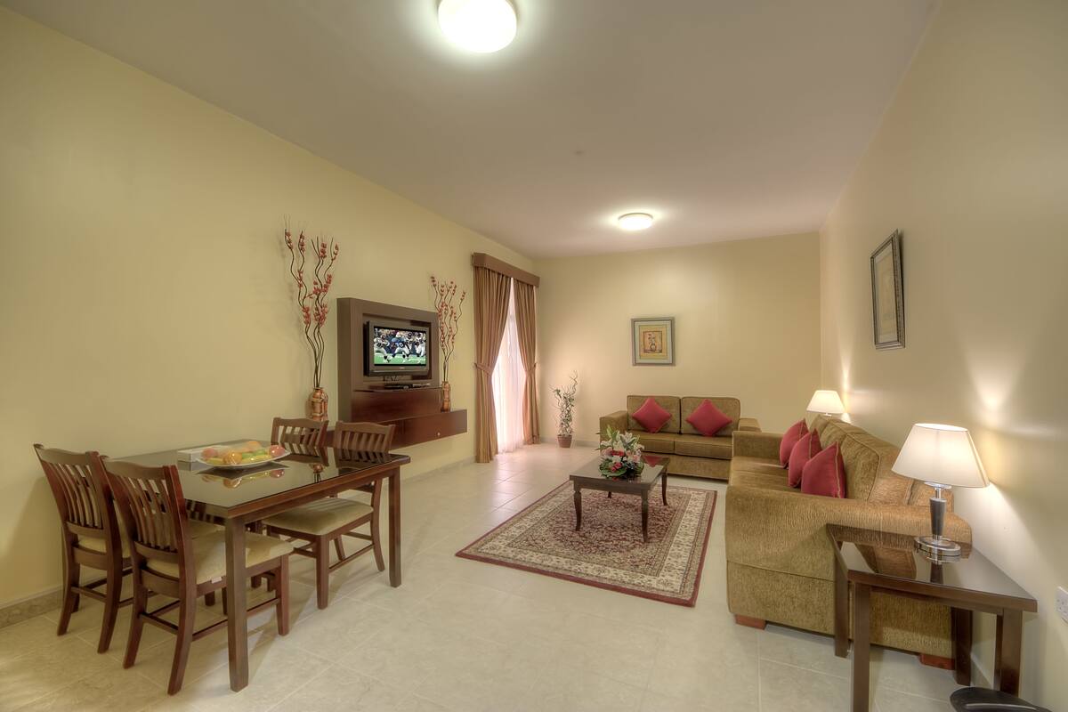 A living room with a sofa, a coffee table, and a TV.