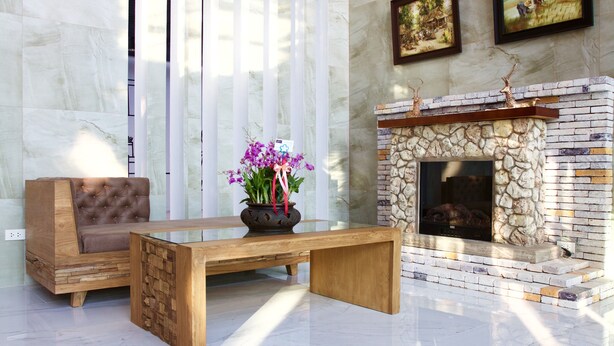 Un salon moderne avec une cheminée en pierre, un banc en bois et un canapé.