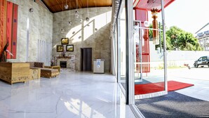 Un hall d’entrée spacieux, doté d’un sol en marbre, de meubles en bois et d’un comptoir d’accueil.