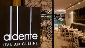 An interior of a restaurant with a sign reading "aldente Italian cuisine". - Social Hotel (Dubai)
