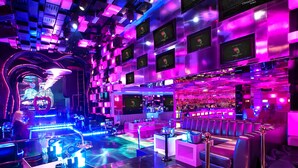Un'area bar vivace con illuminazione al neon, un bancone e posti a sedere.