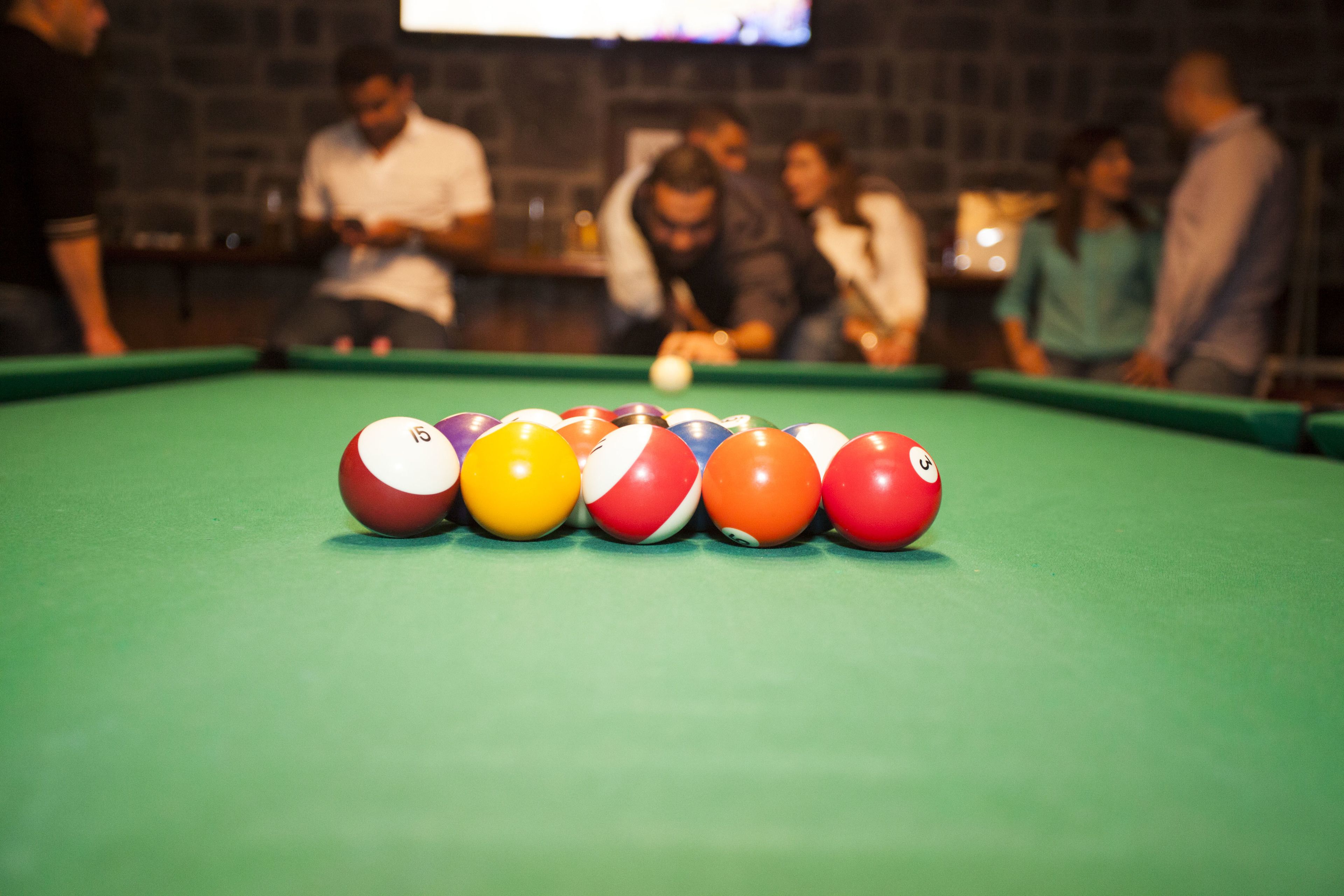 A pool table with balls arranged in a triangle formation.