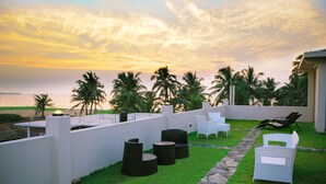 A rooftop terrace with outdoor seating, a view of the ocean, and palm trees. - Blue Water Boutique Hotel (Negombo)