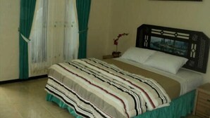 A bedroom with a bed, curtains, a painting, and a nightstand. - Seulawah Resort And Cafe (Batu)