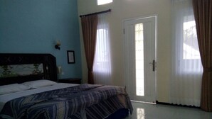 A bedroom with a bed, a door, and curtains. - Seulawah Resort And Cafe (Batu)