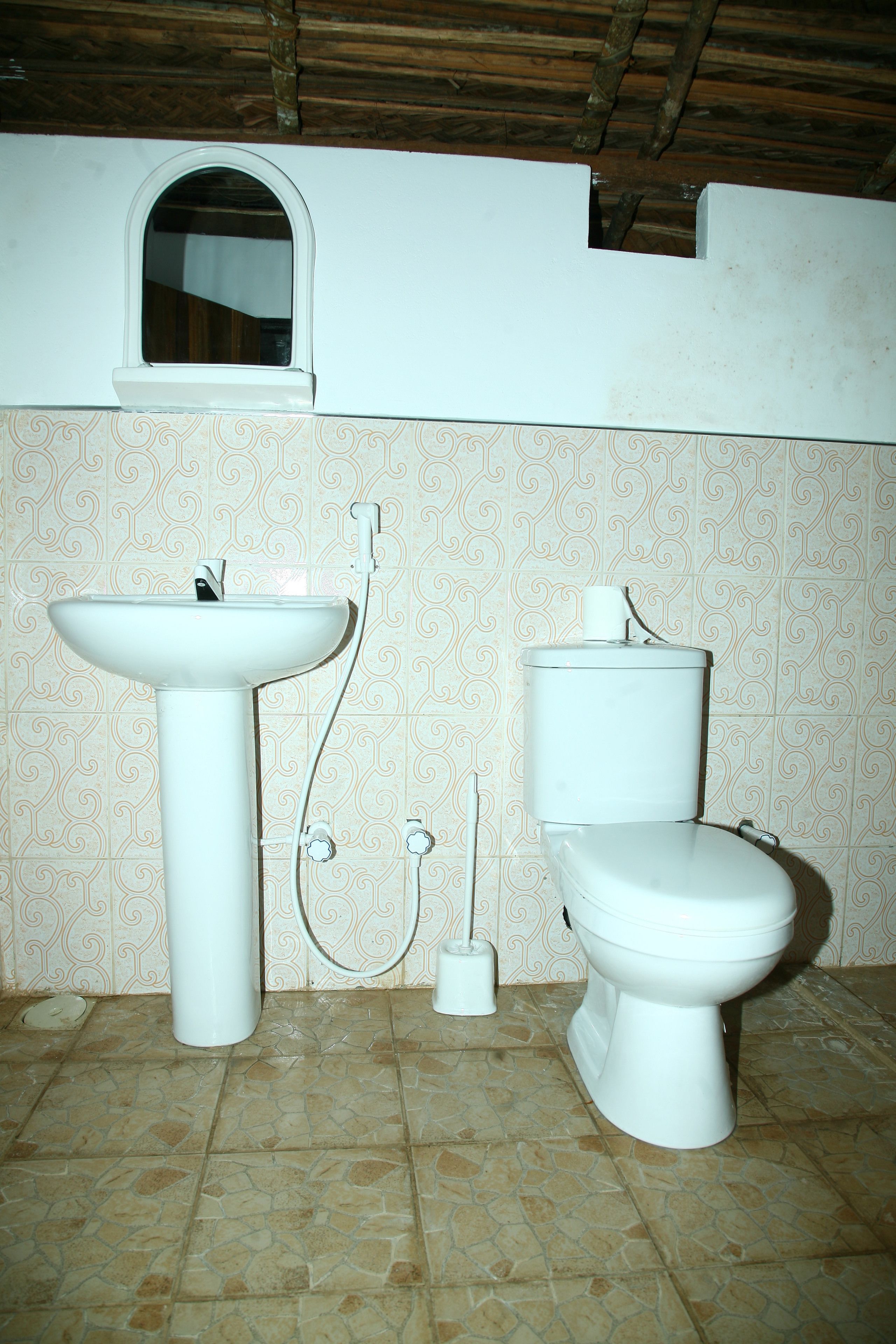 A bathroom with a sink, toilet, and window.
