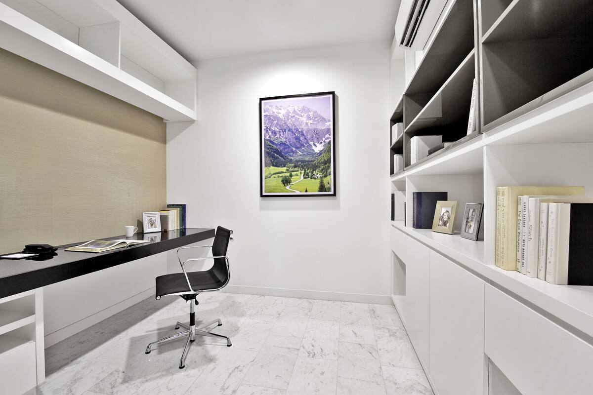 A modern office with a desk, chair, and bookshelves.