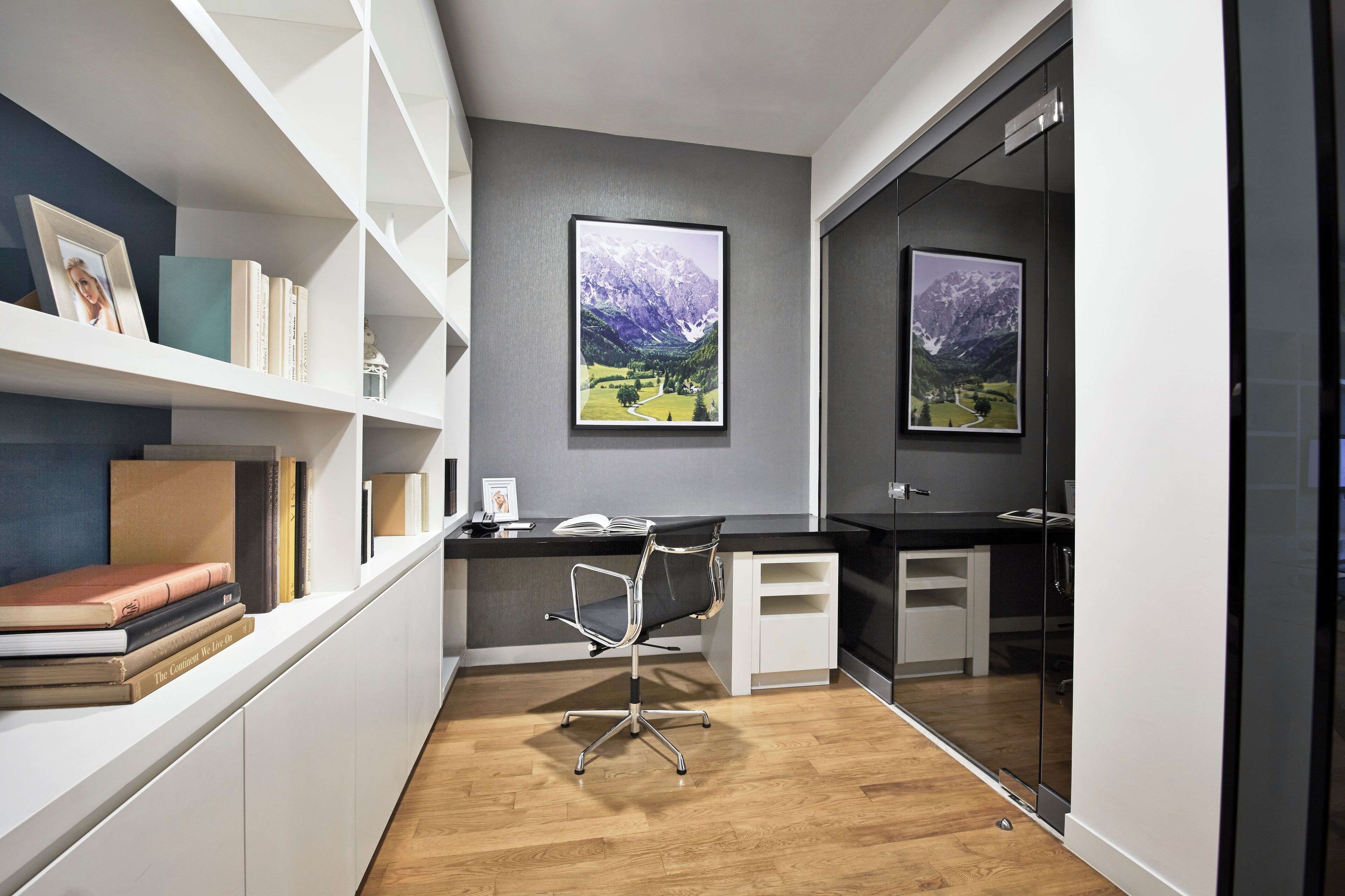 A modern office space with a desk, chair, and bookshelves.
