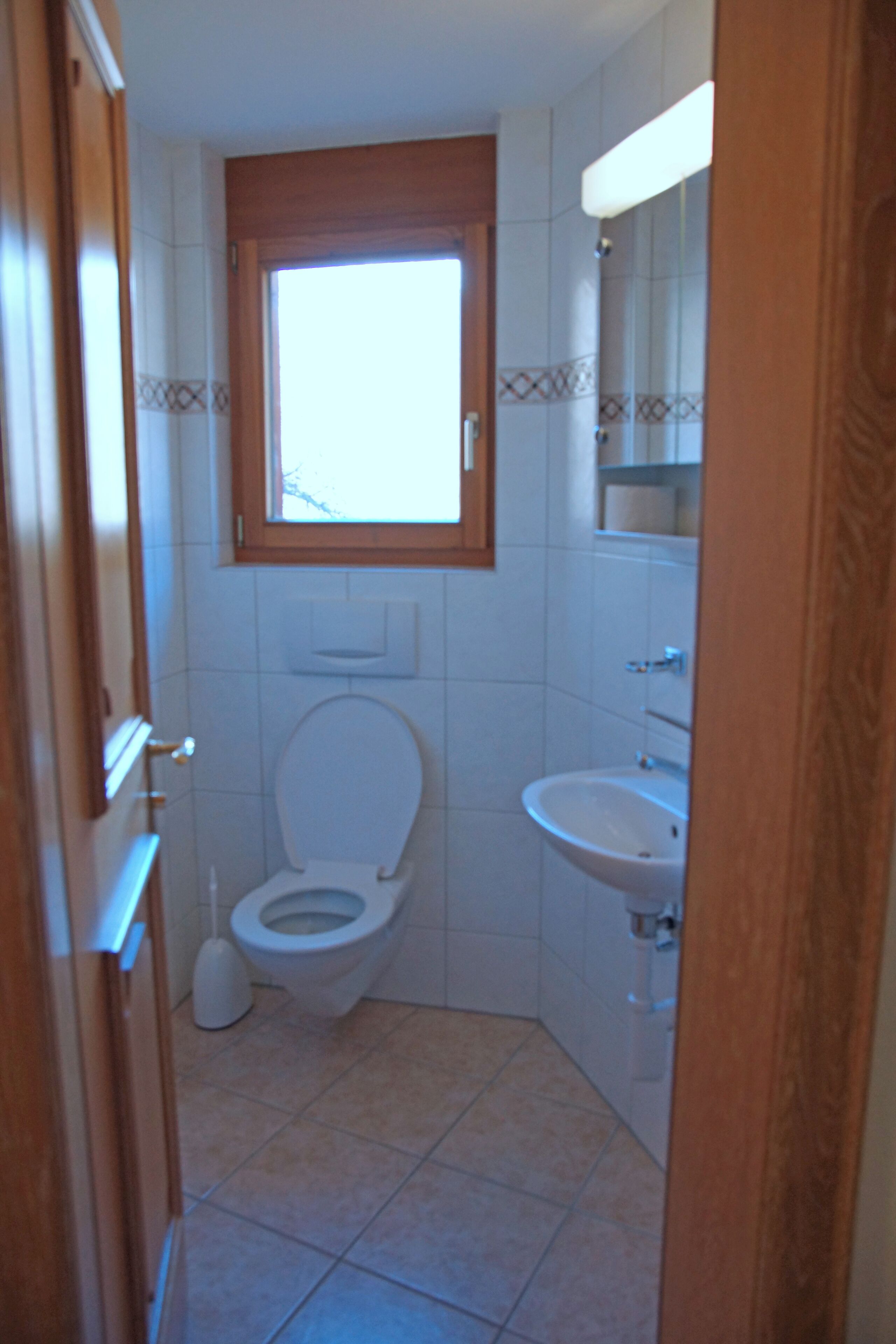 Ein Badezimmer mit Toilette, Waschbecken und Fenster.