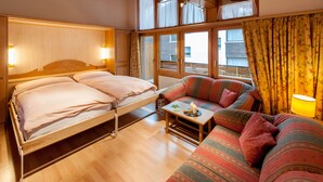 Et hyggeligt værelse med en seng, en sofa og et bord med en lampe.
