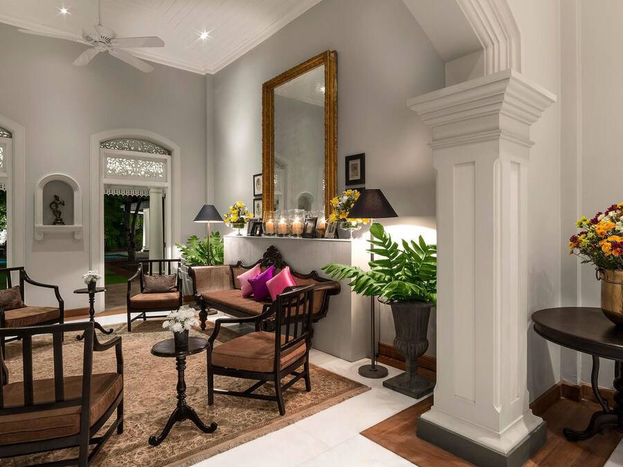 Un amplio espacio habitable con vistas a la piscina, muebles elegantes y un espejo grande.