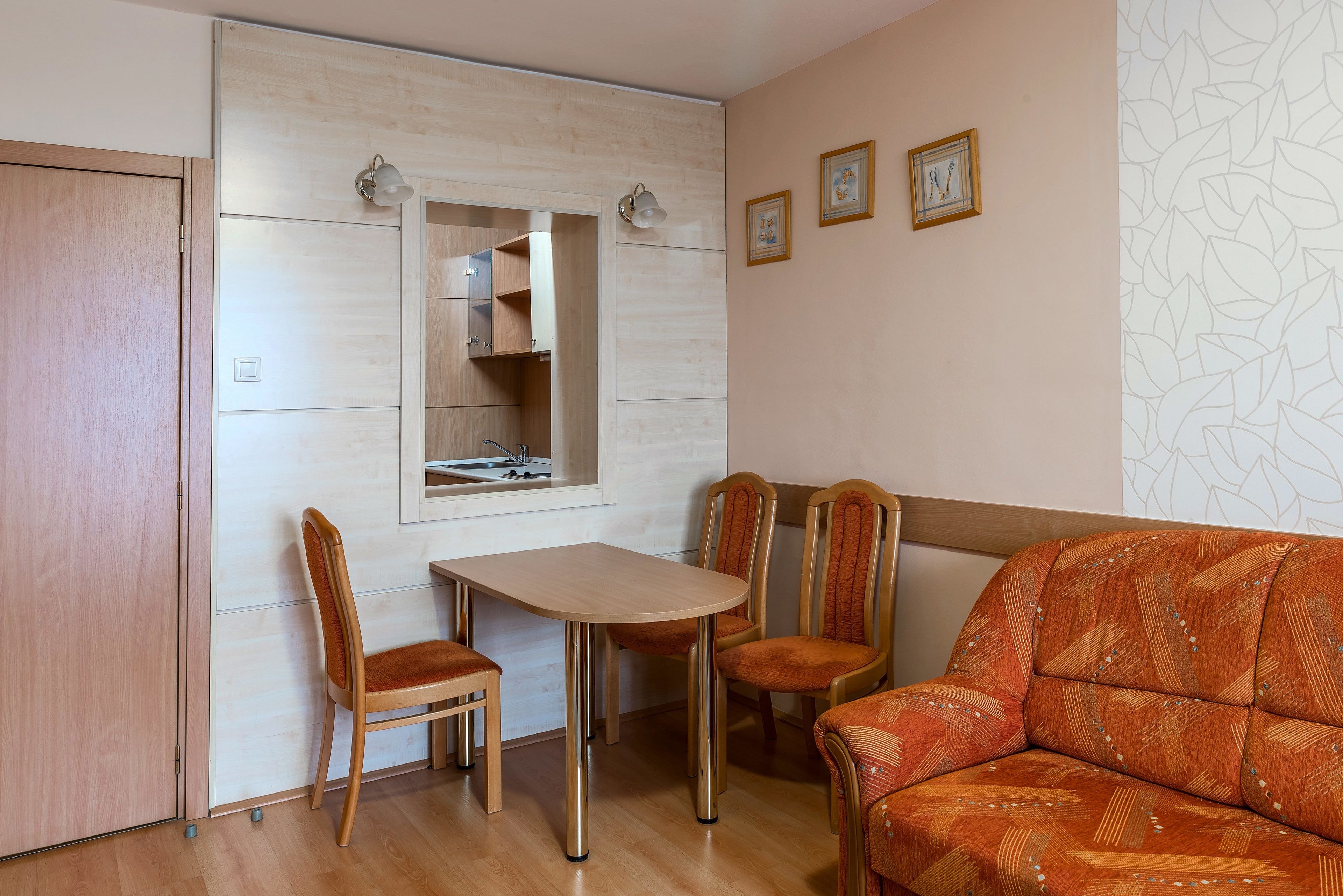 Un espacio habitable compacto con comedor, sofá y kitchenette.