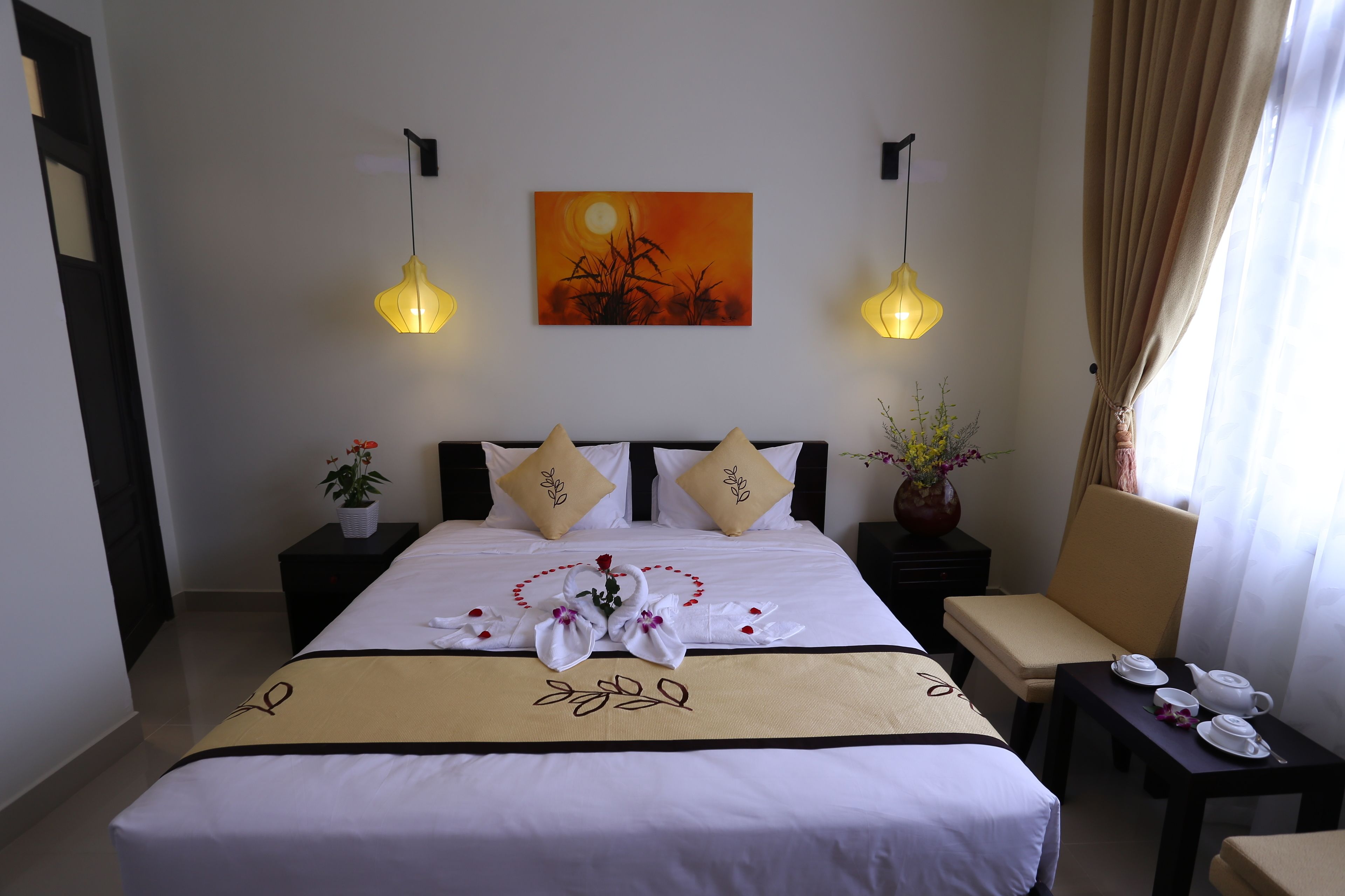 A hotel room with a neatly made bed, two bedside tables with lamps, a painting on the wall, and a window with curtains.