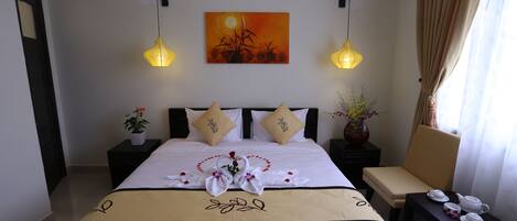 A hotel room with a neatly made bed, two bedside tables with lamps, a painting on the wall, and a window with curtains.