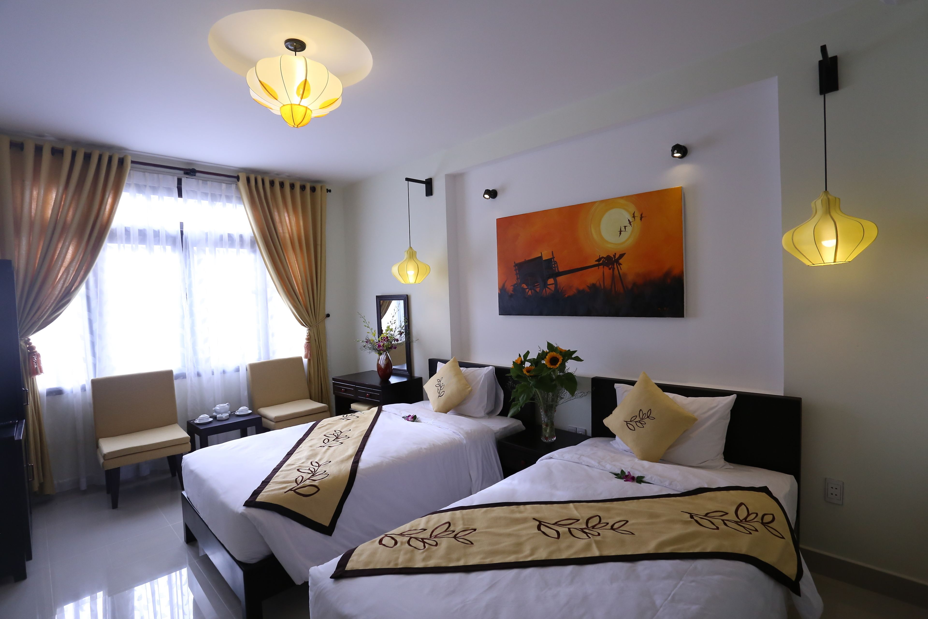 A hotel room with two beds, a desk, a chair, and a painting on the wall.