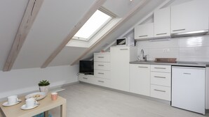 A modern kitchen with white cabinetry, a Koncar refrigerator, and a skylight. - Villa Providenca (Dubrovnik)