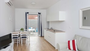 A compact living space with a kitchenette, a dining area, and a sofa. - Apartments Villa Karmen (Dubrovnik)