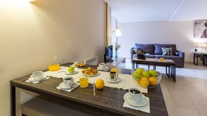 A breakfast setup with a coffee table, breakfast items, and a living area with a sofa and TV.