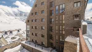 A multi-story building with a stone facade, large windows, and a balcony with a metal railing. - Pierre & Vacances Pas de la Casa Princesa (Pas de la Casa)