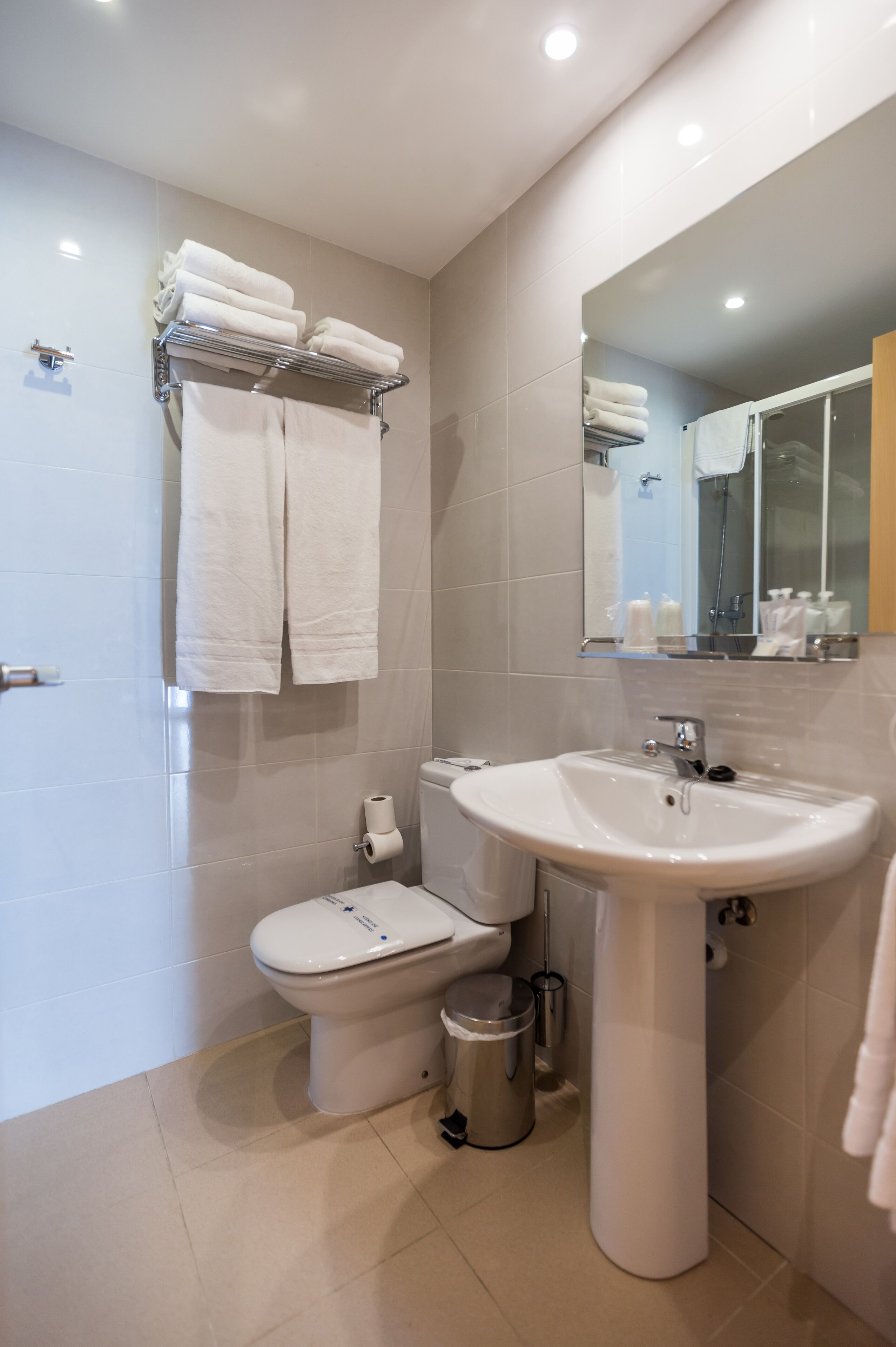 A modern bathroom with a toilet, sink, and towel rack.