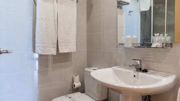 Een moderne badkamer met toilet, wastafel en handdoekhouder.