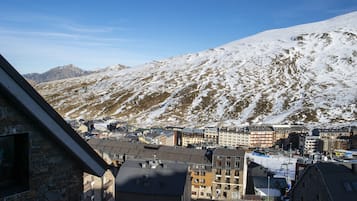 A town with snow-covered mountains in the background and buildings with multiple stories in the foreground.
