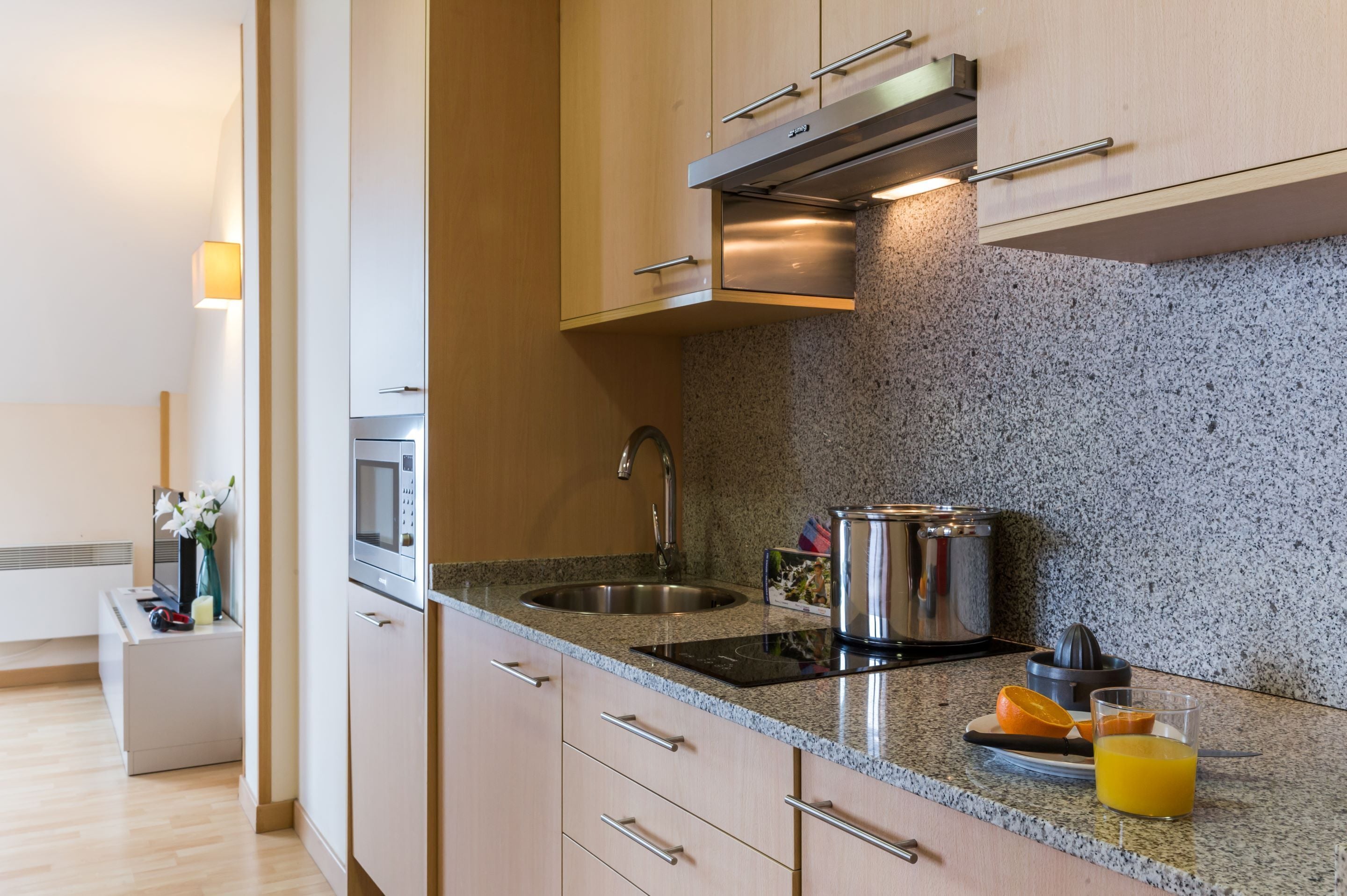 A modern kitchen with granite countertops, stainless steel appliances, and wooden cabinets.