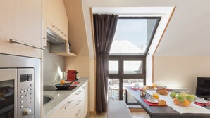 A modern kitchen with a built-in oven and a dining area with breakfast items.