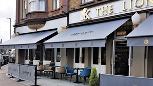 Exterior d'un hotel amb seients a l'aire lliure i un cartell que diu "The Lion & Key Hotel".