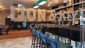 Zona de bar amb un cartell que diu "LION & KEY CAFE BAR GRILL".
