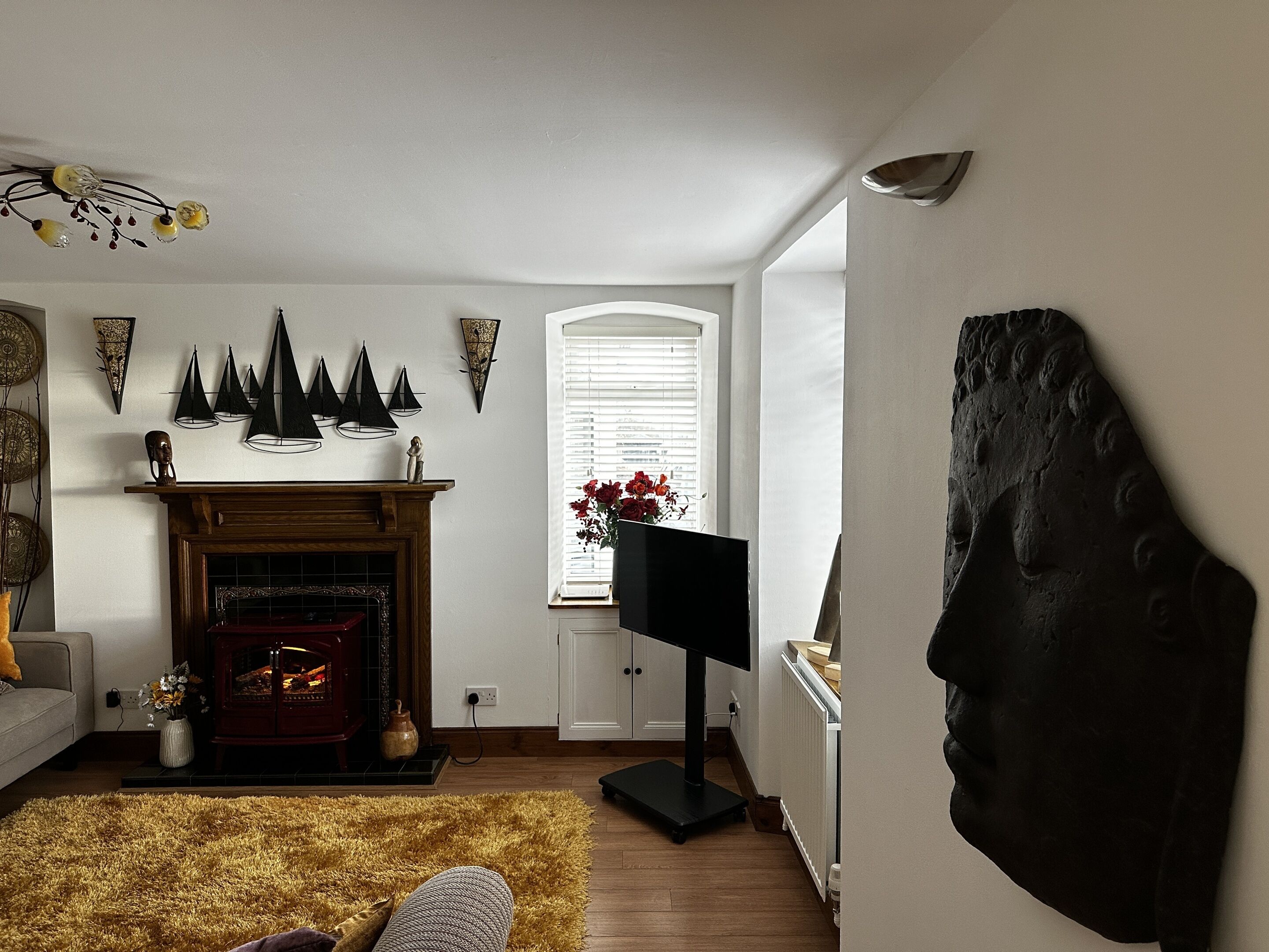 Un salon doté d’une cheminée, d’un téléviseur et d’une grande sculpture abstraite.