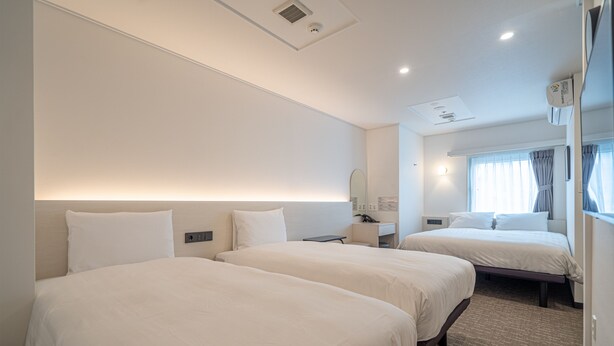 A hotel room with two beds, a desk, a mirror, and a window with curtains. - Toyoko Inn Seoul Dongdaemun 1 (Seoul)