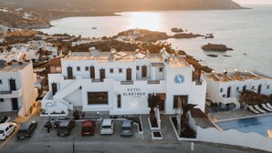 Un edificio blanco con un cartel que dice 'HOTEL ALBATROS' y una zona de piscina.